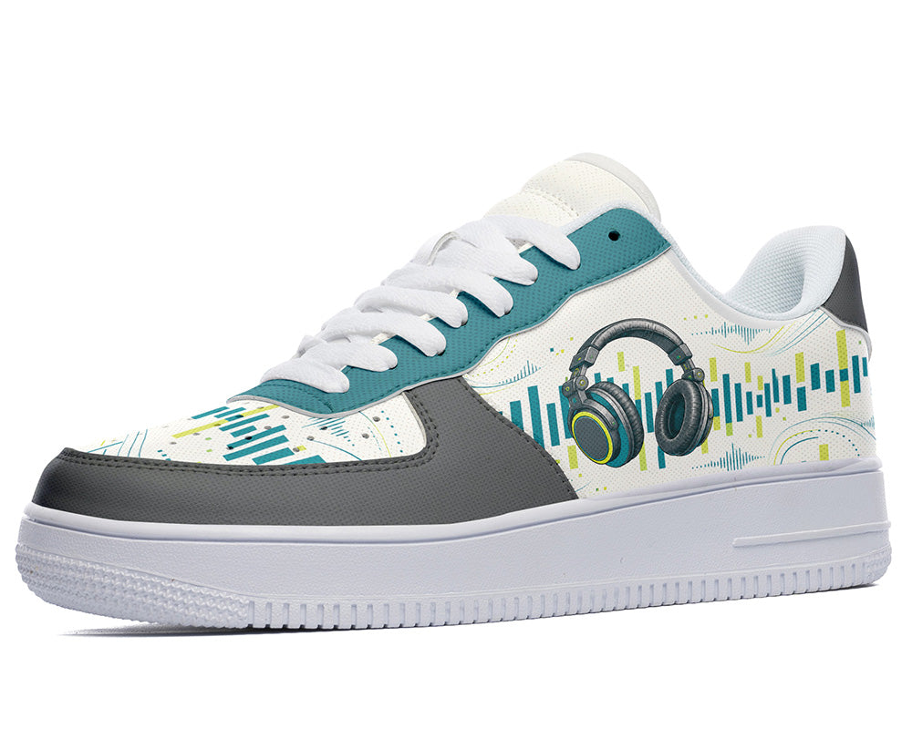 A low-top sneaker with a white base, gray toe and heel panels, teal overlays, and a side graphic featuring headphones and soundwave lines in teal, yellow, and gray.