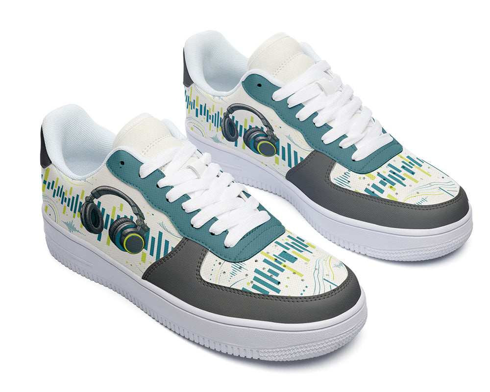 A pair of low-top sneakers with a white base, teal and dark gray panels, and a graphic print featuring headphones and abstract teal and yellow lines on a white background.