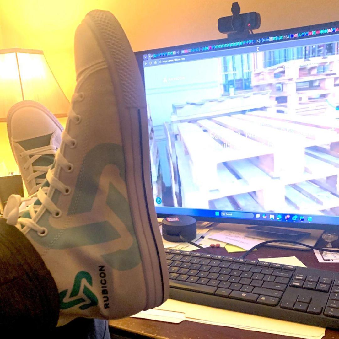 Rubicon branded custom high top sneakers displayed next to a computer screen of a Rubicon recyclable pallet
