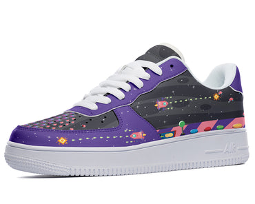 A low-top sneaker with a black upper. The upper is decorated with a colorful pattern of rockets, flowers, and geometric shapes. The sneaker has a white midsole and outsole.