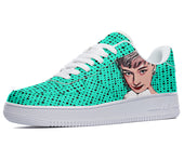 A close-up of a sneaker with a green and white polka dot pattern. The sneaker has a white sole and white laces. The face of a woman with short dark hair is depicted on the side of the shoe.