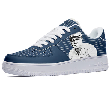 A close-up of a blue sneaker with a white sole and white laces. The sneaker has a design of a baseball player on the side.