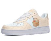 White sneakers with a light blue and beige woven pattern featuring a basket full of holiday gifts. 
