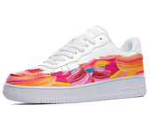 White low-top sneakers with an abstract paintbrush design in pink, yellow, and blue. 