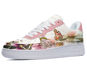 A white sneaker with a pink swoosh and a floral and butterfly design on the upper.