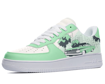 A green and white sneaker with a design of a blue car on the side. The car is surrounded by palm trees and buildings.