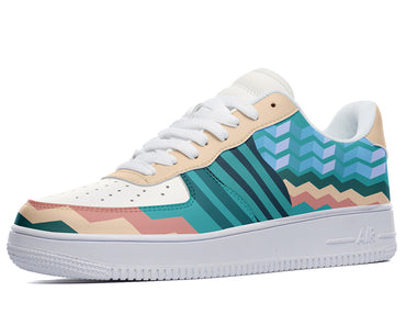 A white sneaker with a geometric pattern on the side. The pattern is made up of light blue, blue, green, and Pink