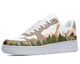 A side view of a sneaker with a white sole, light brown upper, and a design of a deer standing in a forest on the side.