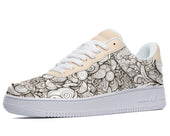 White low-top sneakers with a black and white doodle design covering the entire shoe. 
