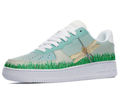 White sneakers with a green and blue ombre design featuring a dragonfly and grass. 