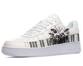 White sneakers with a black and white illustration of a drum set on the side, with piano keys at the bottom of the design. 
