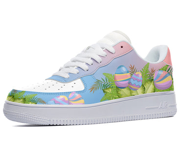 A white sneaker with a colorful design on the sides. The design features Easter eggs, leaves, and ferns in shades of pink, blue, purple, and green.