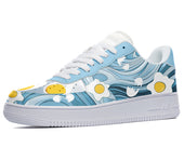 A blue sneaker with a white sole, white laces, and a design of eggs and bacon on the upper.