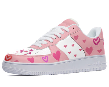 A pink and white sneaker with a heart-shaped pattern.