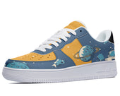 A side view of a sneaker with a design of an astronaut on the moon, planets, and stars on a blue background. The shoe is yellow at the toe and white at the tongue, laces, and sole.