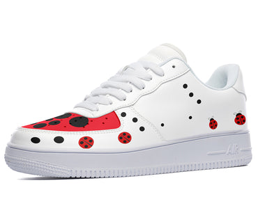 White sneakers with a red and black ladybug design. The design features ladybugs of various sizes scattered across the shoe.