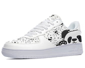 A white sneaker with a design of black and white cartoon pandas on the sides and black stars on the rest of the shoe.