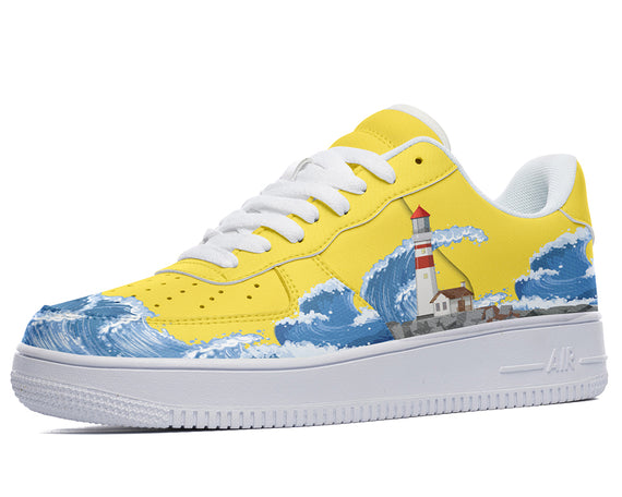 A yellow sneaker with a white sole and white laces. The sneaker has a design of a lighthouse on a rocky cliff with blue waves crashing against it.