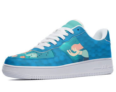 A blue sneaker with a pattern of a mermaid swimming in the ocean. The mermaid has long, flowing hair and a colorful tail. The shoe has white laces and a white sole.