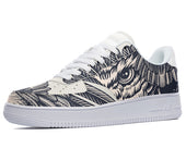 A black and white sneaker with a design of an owl's face on the side. The owl is surrounded by feathers and has its eyes wide open.