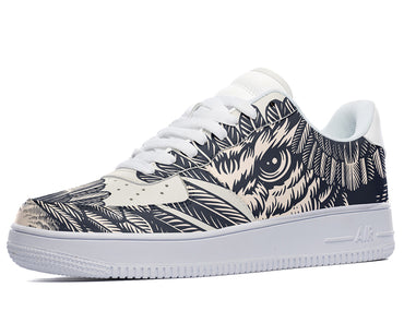 A black and white sneaker with a design of an owl's face on the side. The owl is surrounded by feathers and has its eyes wide open.