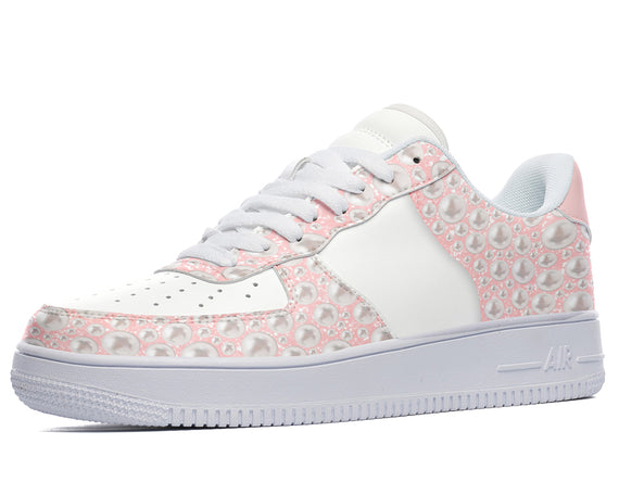 White low-top sneakers with a pink and white pearl design. 