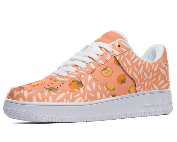 A white sneaker with a pattern of peaches and leaves on the upper.