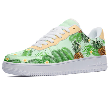 A green sneaker with a white sole, white laces, and a design of pineapples, palm leaves, and flowers on the upper.