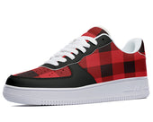 A low-top sneaker with a red and black plaid pattern and a white sole.