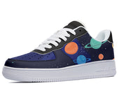 Low-top sneakers with a blue, black, and white outer sole and an outer fabric featuring a design of planets and stars on a dark blue background. 