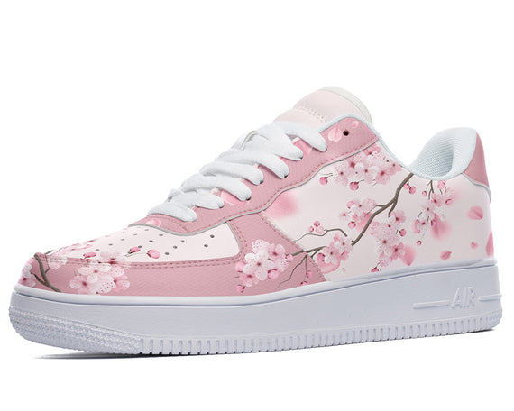 A pink sneaker with a white sole and white laces. The sneaker has a floral pattern of cherry blossoms on the upper.