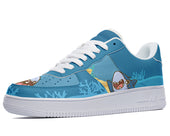 A blue sneaker with a great white shark, a yellow tang fish, and coral on the side. The shark has its mouth open and is showing sharp white teeth.