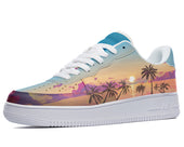 A side view of a sneaker with a white sole, white laces, and a light blue toe and heel. The body of the sneaker is decorated with a colorful design of a sunset over palm trees.