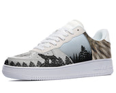 A white sneaker with a design of a wolf howling at the moon on the side. The wolf is surrounded by a forest of pine trees.