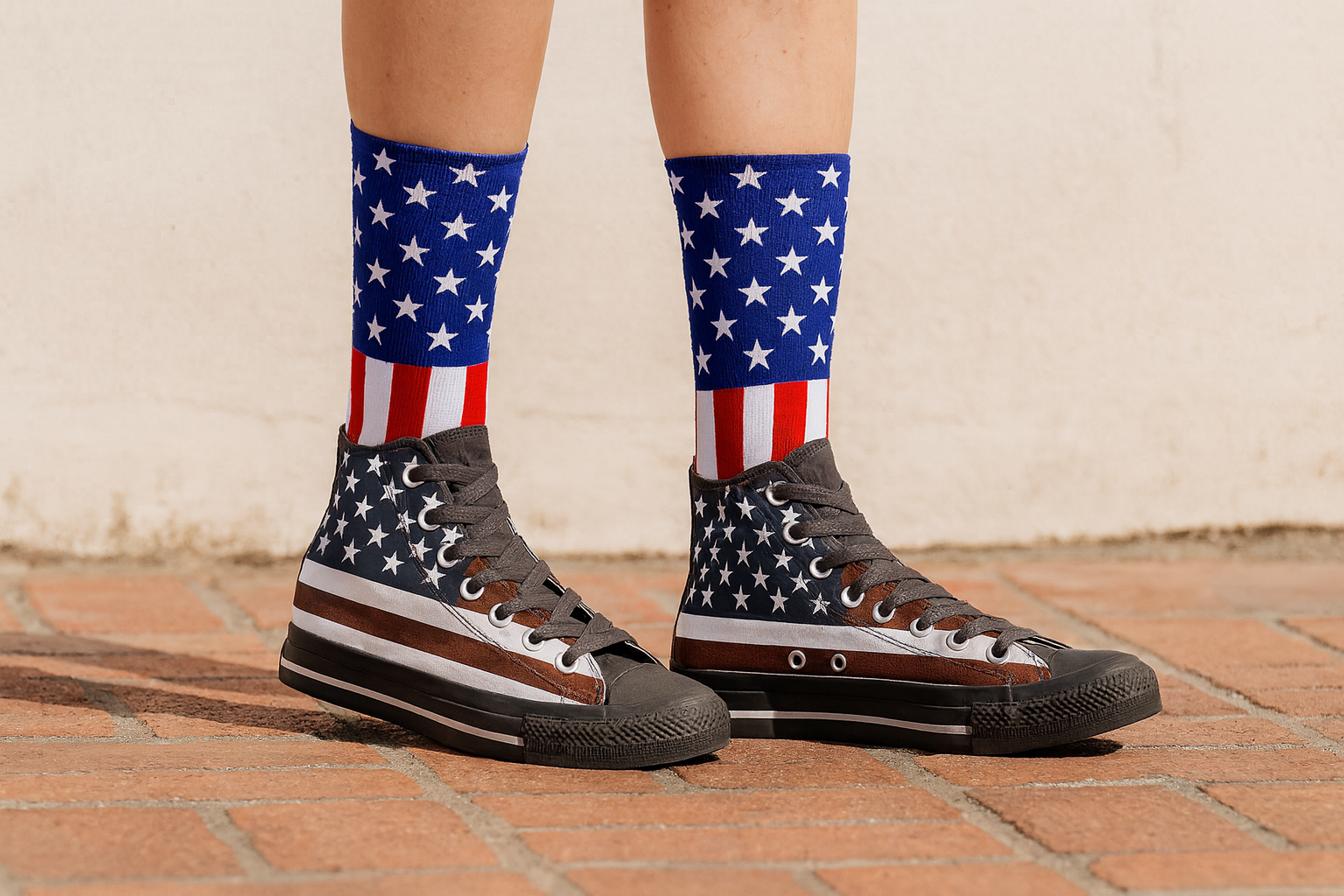 Person wearing American flag socks and high-top sneakers on a brick surface.