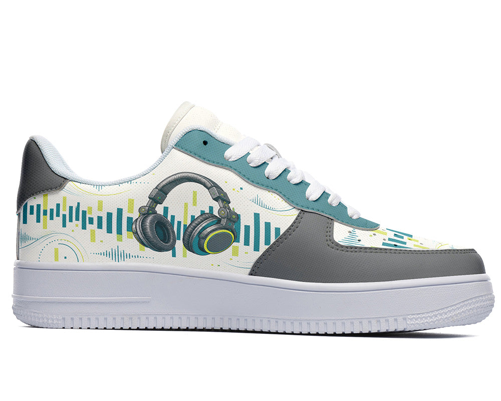 A low-top sneaker with a white and gray leather base, decorated with teal and yellow audio wave graphics and a large headphone illustration on the side, set against a plain white background.