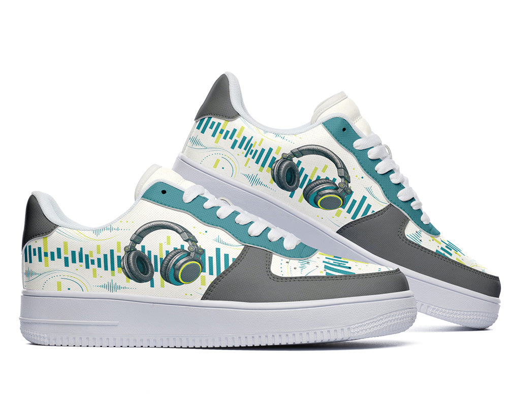 A pair of low-top sneakers with a white base, gray overlays, teal accents, and a graphic print featuring headphones and soundwave patterns on the sides.