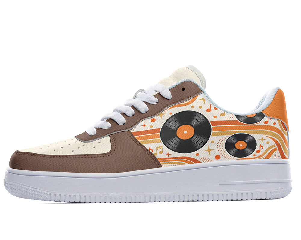 Court sneaker in white sole with a side view featuring black vinyl LP records over orange and cream retro wave lines with brown leather overlays.