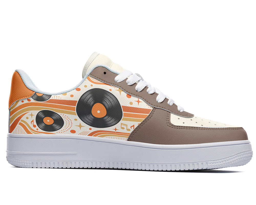 Court sneaker in white sole with a side view featuring black vinyl LP records over orange and cream retro wave lines with brown leather overlays.