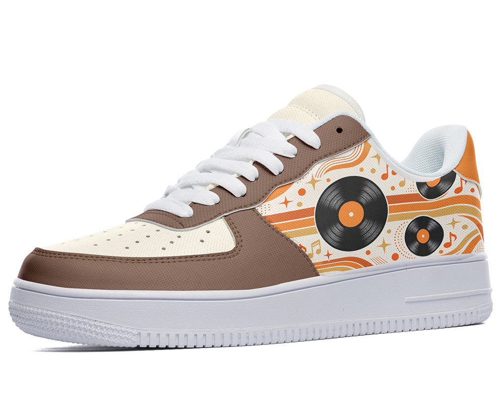 Court sneaker in white sole with a side view featuring black vinyl LP records over orange and cream retro wave lines with brown leather overlays.